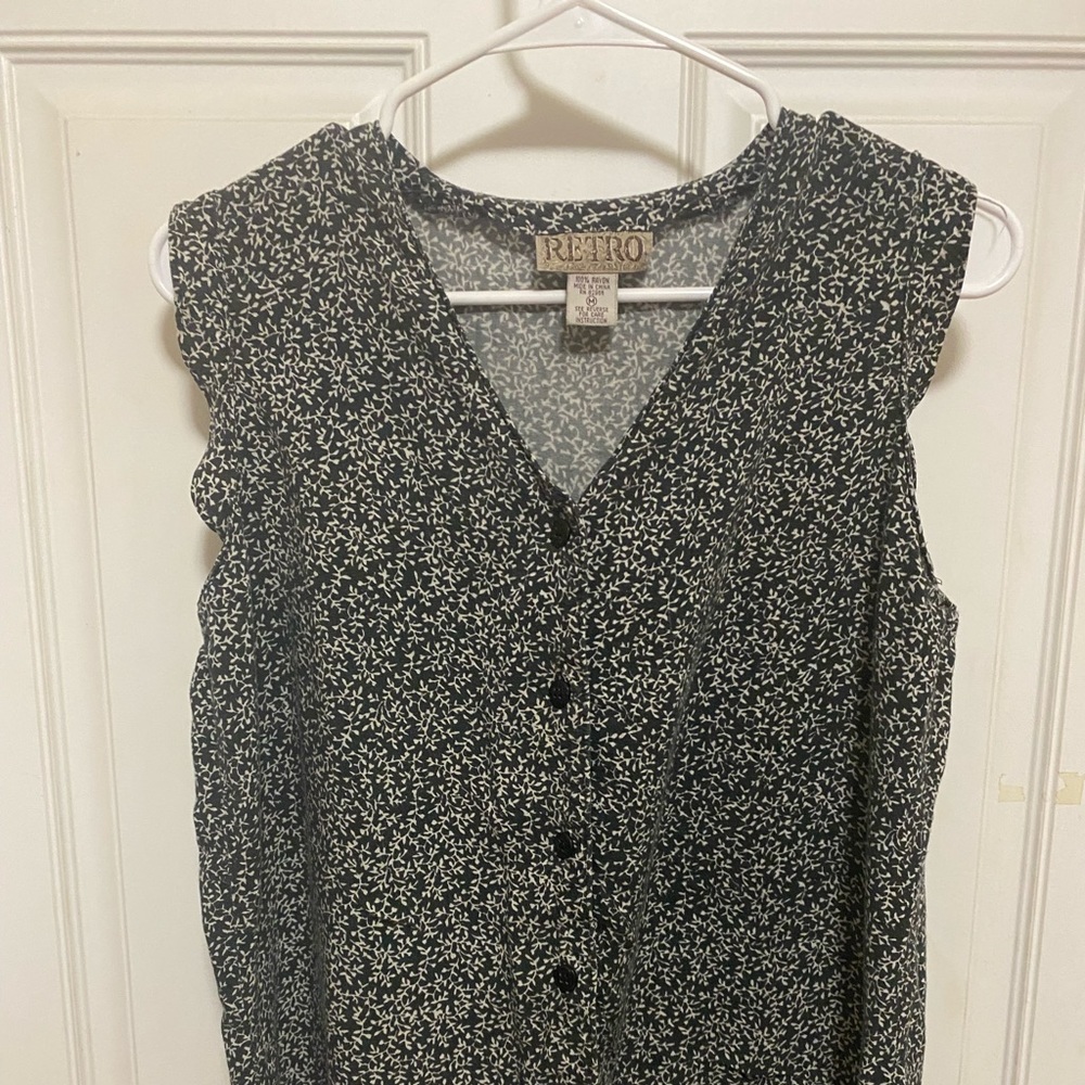 Black & white sleeveless button up top. Slightly ruffled edge around arms